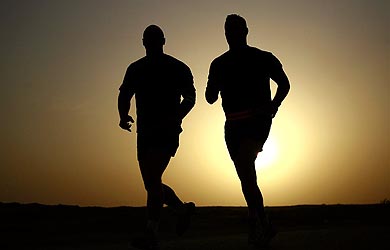 Sunset silhouette of two men running